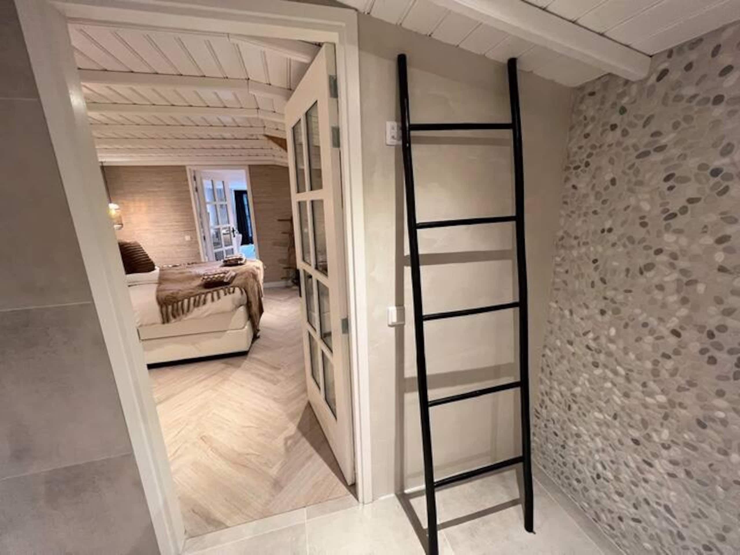 Doorkijk van de badkamer naar de slaapkamer in Oester