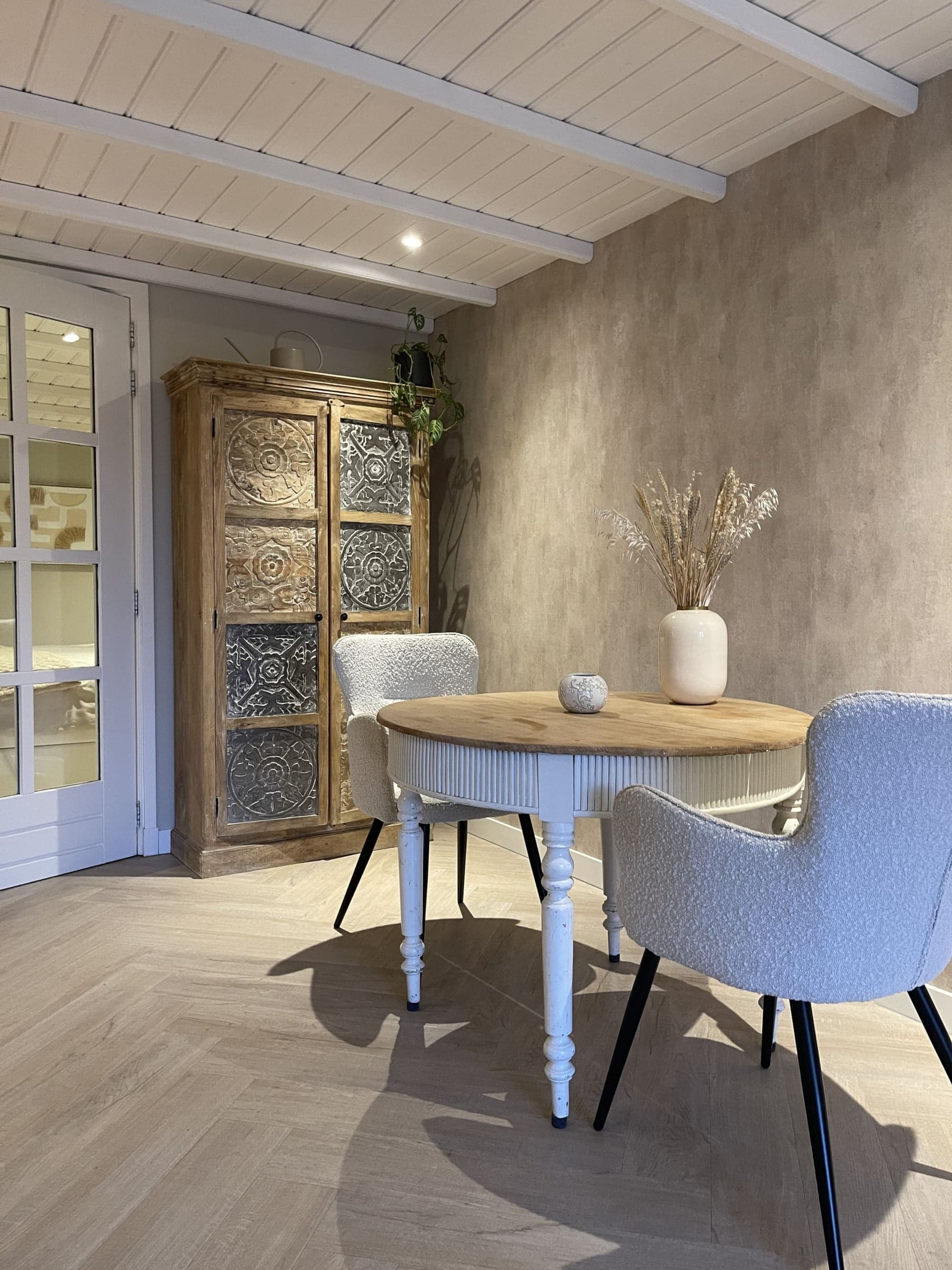 Eethoek met ronde tafel en houten kast in Oester