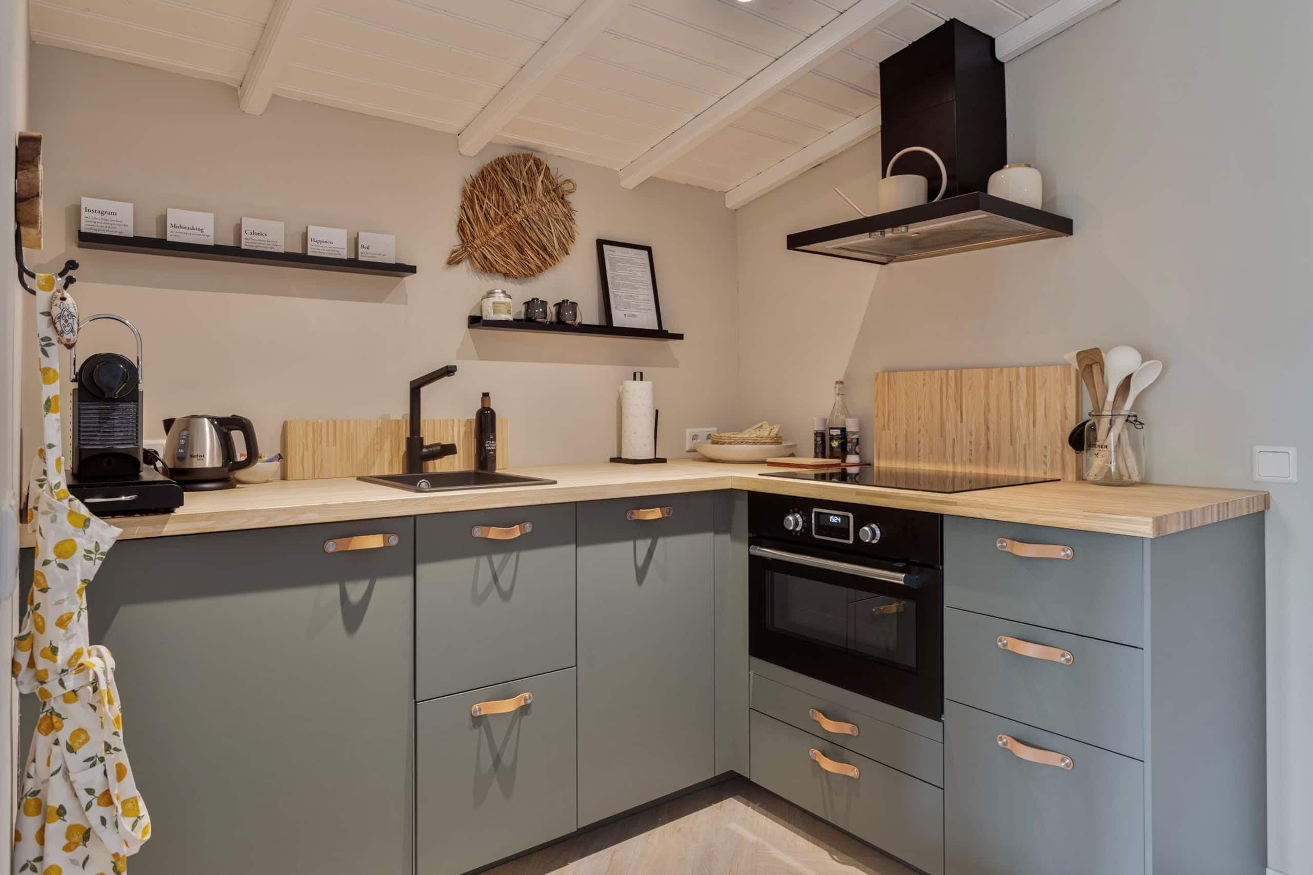 Keuken van Oester met groene kastjes, oven en afzuigkap