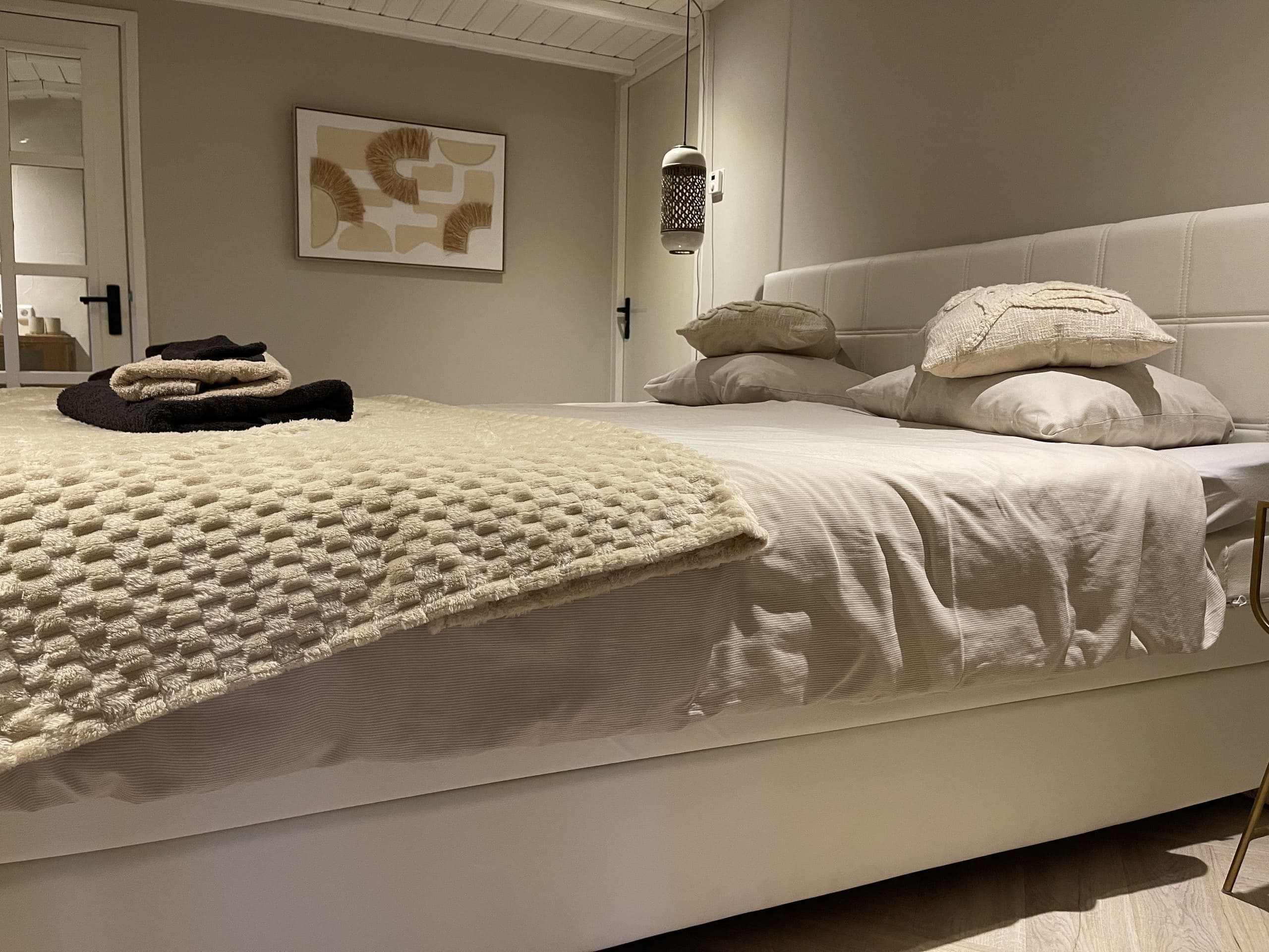 Bed met plaid in de slaapkamer van Oester
