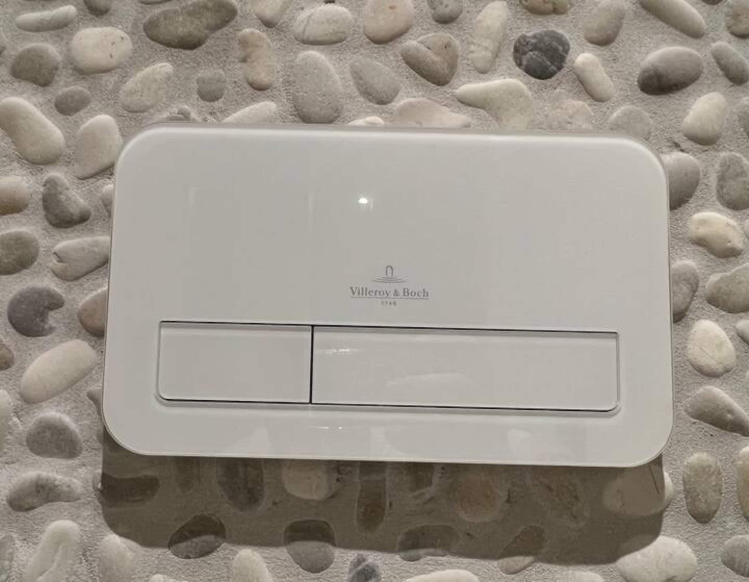 Spoelknop op een muur met kiezels in Oester