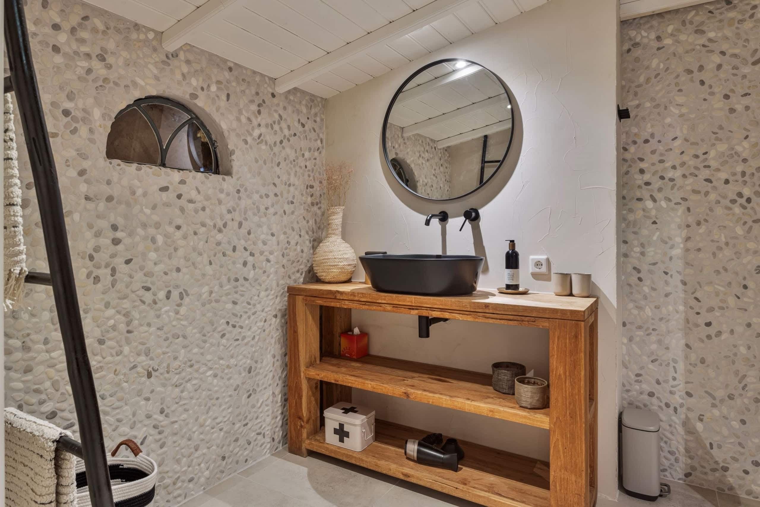 Wastafel met houten meubel in de badkamer van Oester