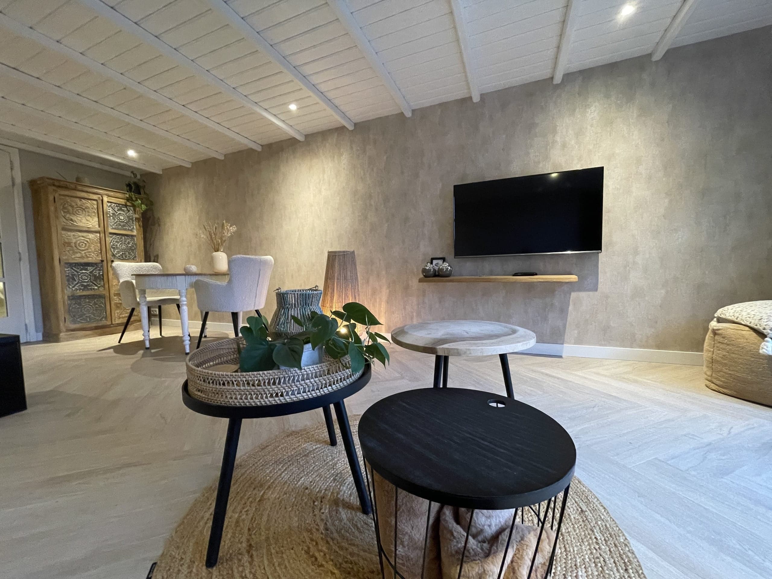 Woonkamer van Oester met salontafels en tv aan de muur
