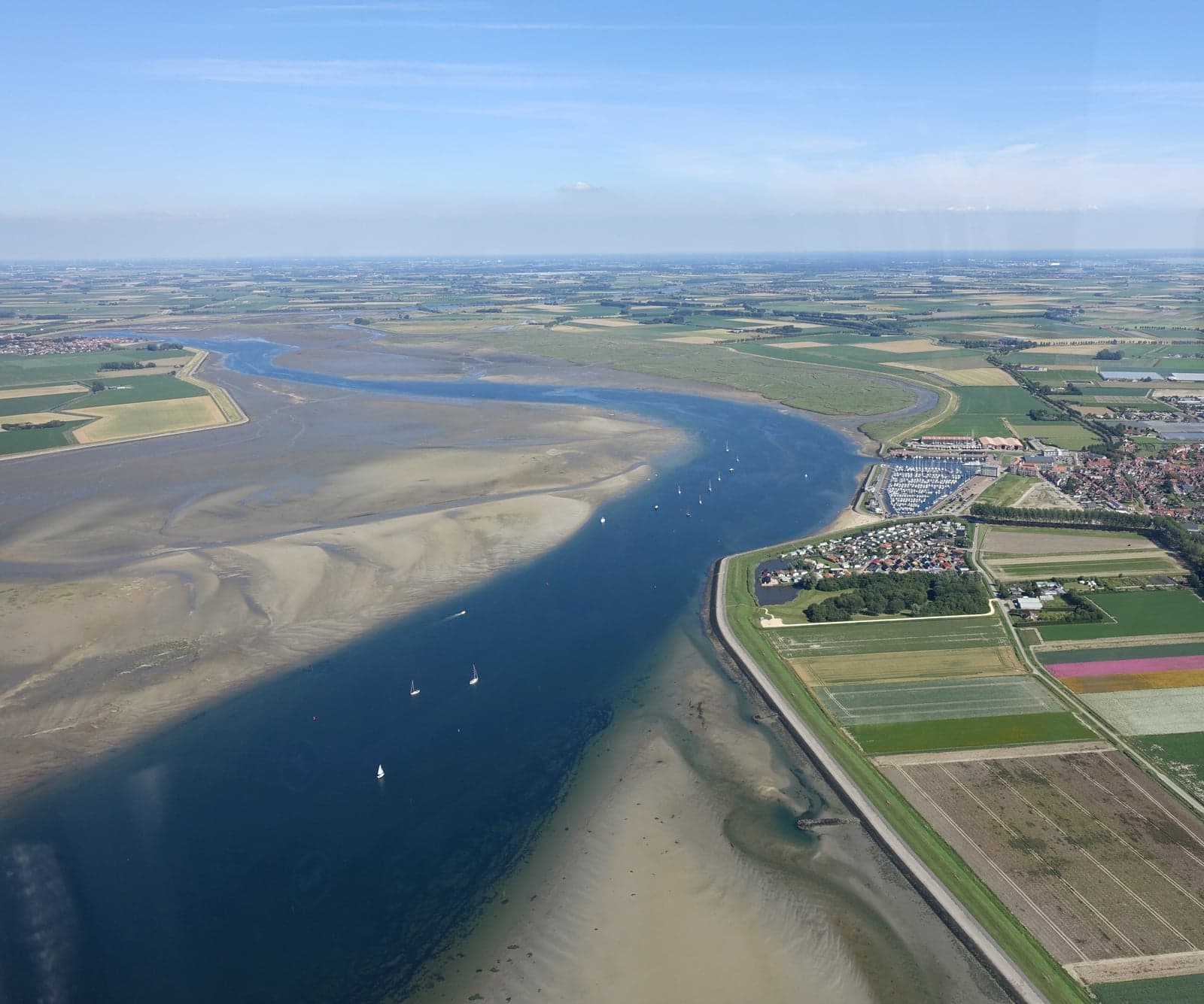 Luchtfoto van de Krabbenkreek met zandplaten, zeilboten en polders langs de dijk