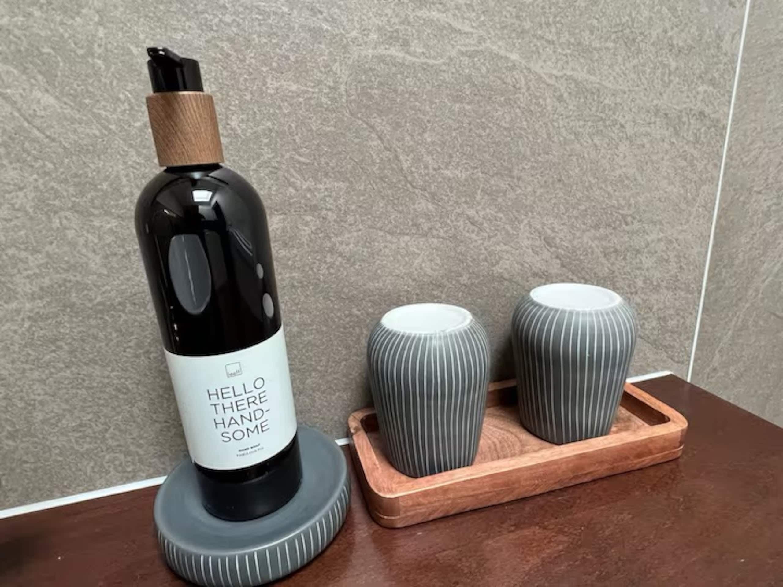 Zeep en bekers op een plank in de badkamer van Zeelicht