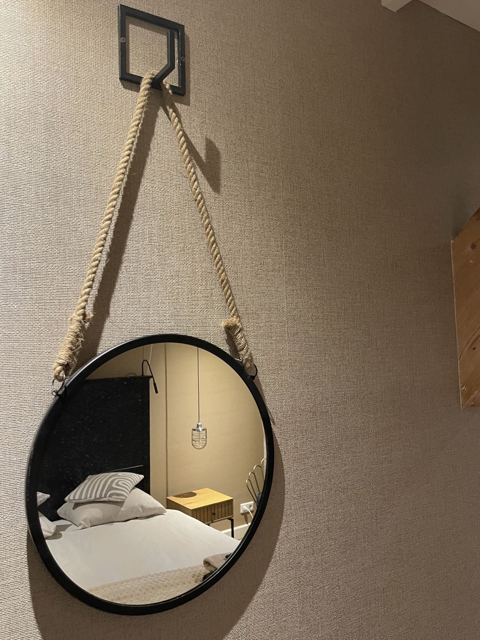 Ronde spiegel aan een touw in de slaapkamer van Zeelicht
