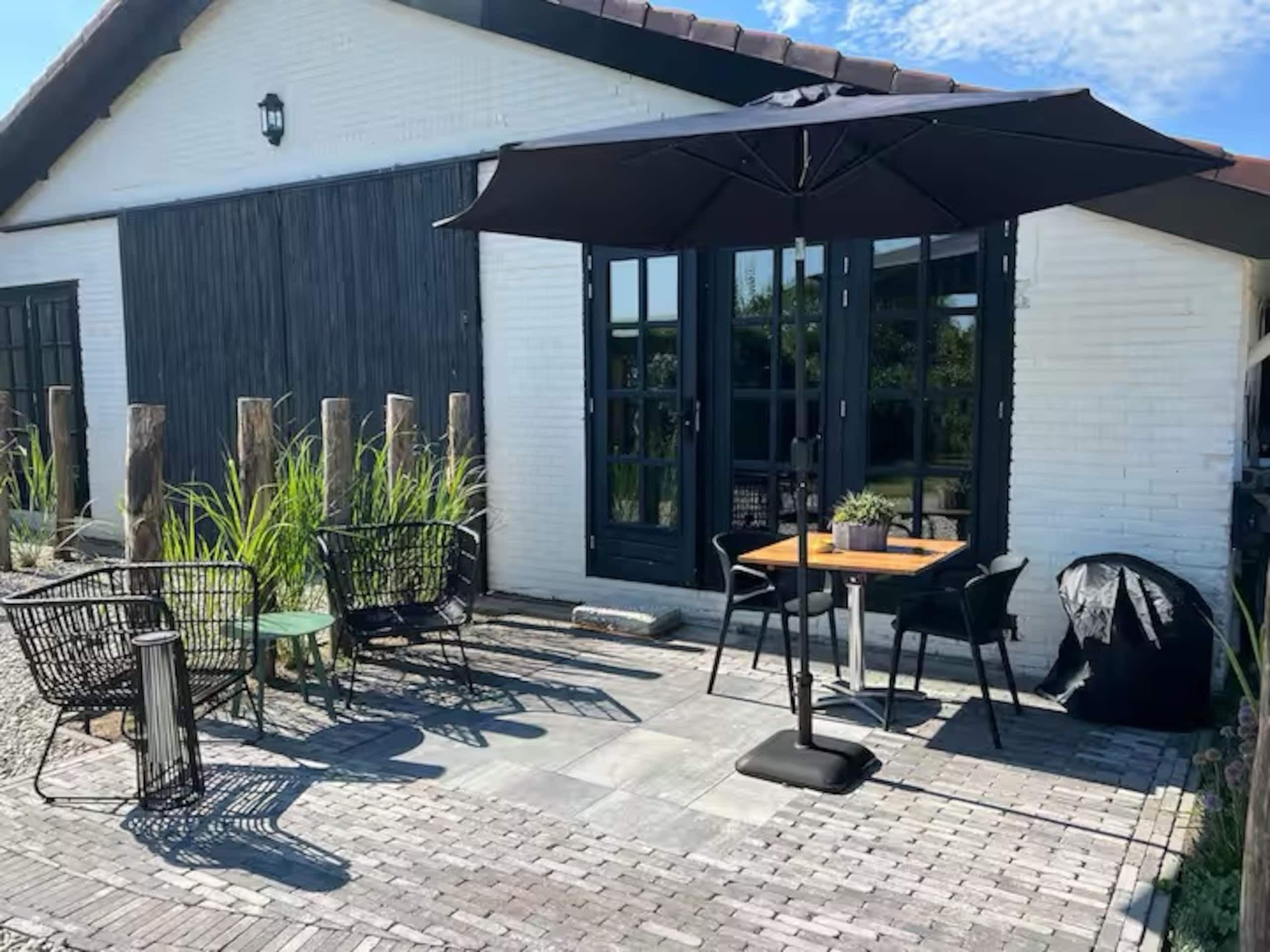 Terras van Zeelicht met stoelen en parasol