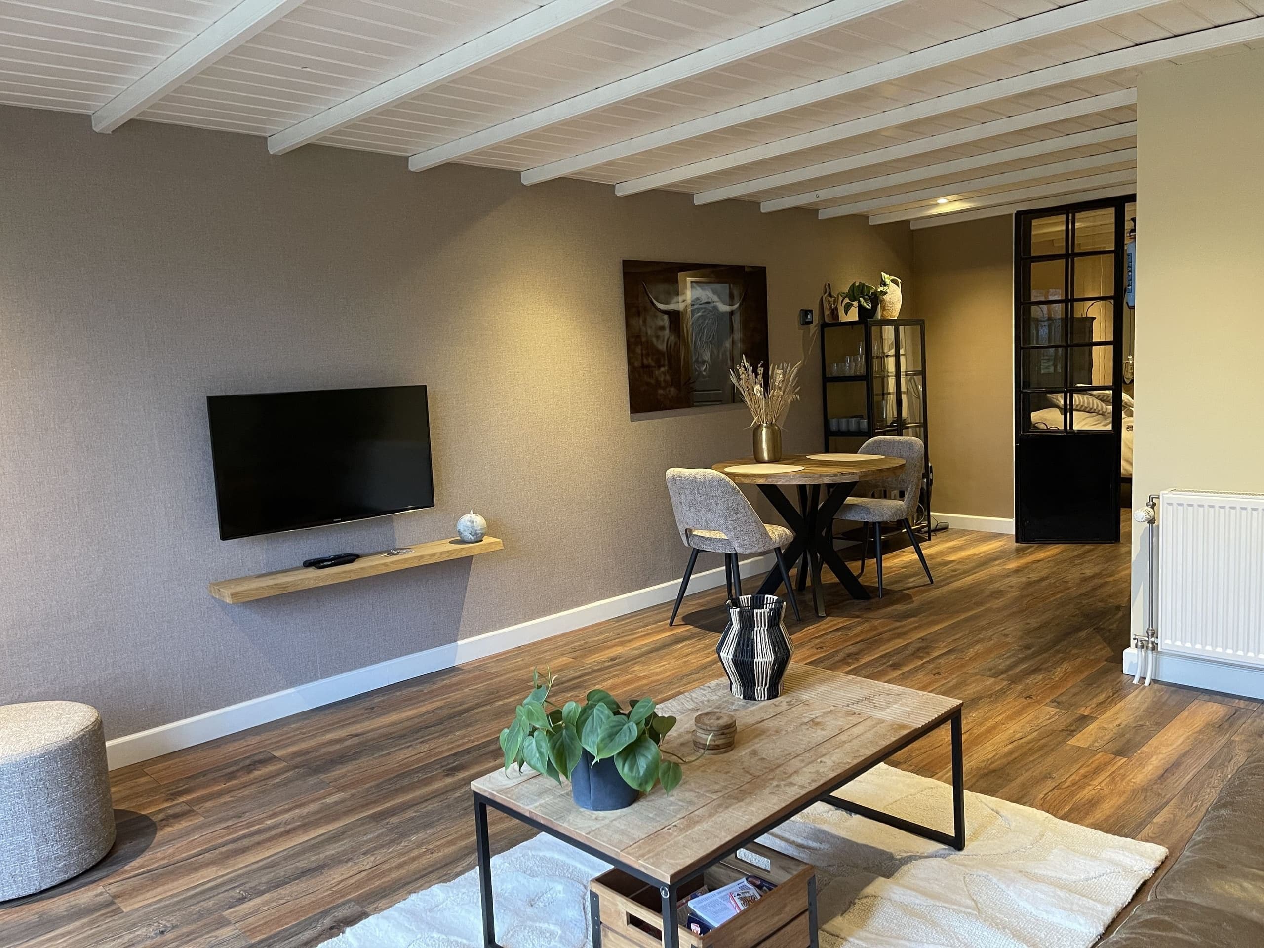 Woonkamer van Zeelicht met tv, salontafel en eethoek